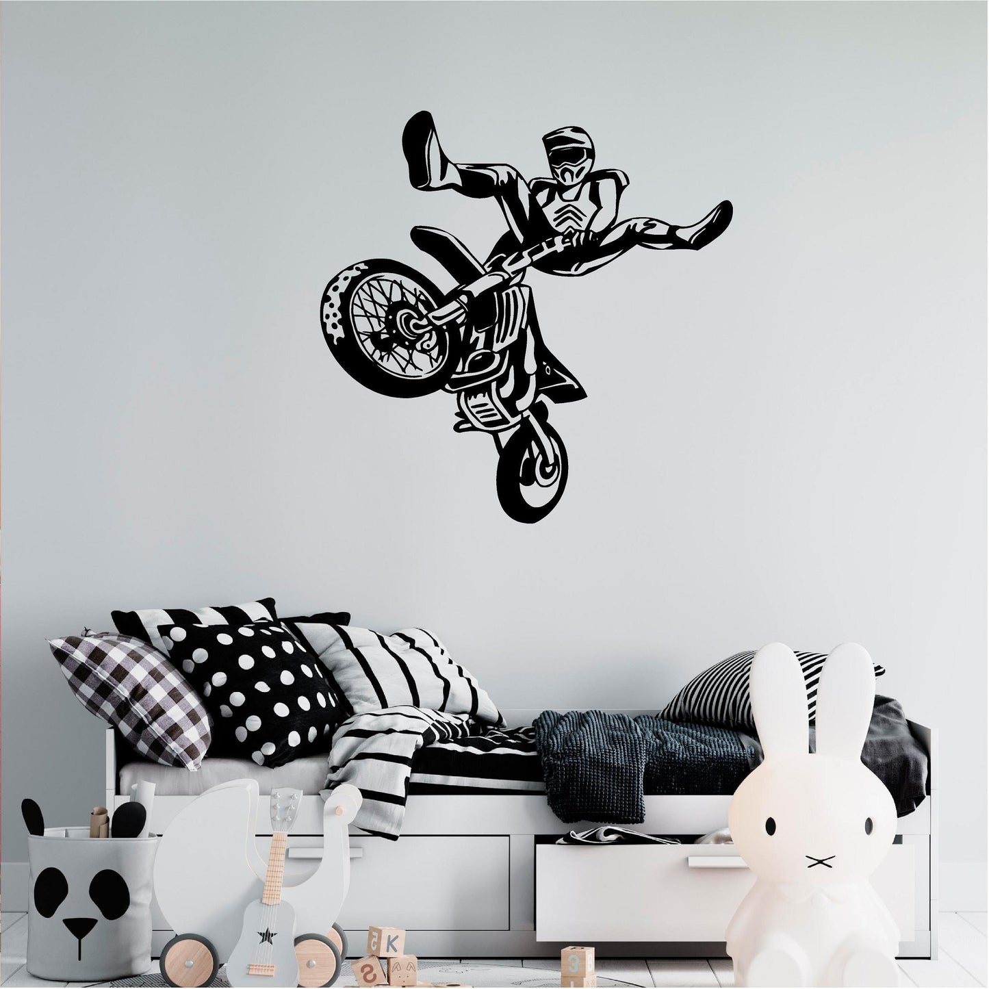 Black freestyle motocross rider wall decal above a child's daybed