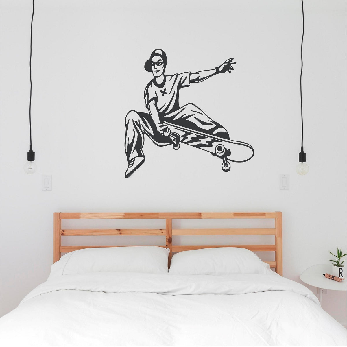 Dark grey skateboarder trick wall decal above a double bed