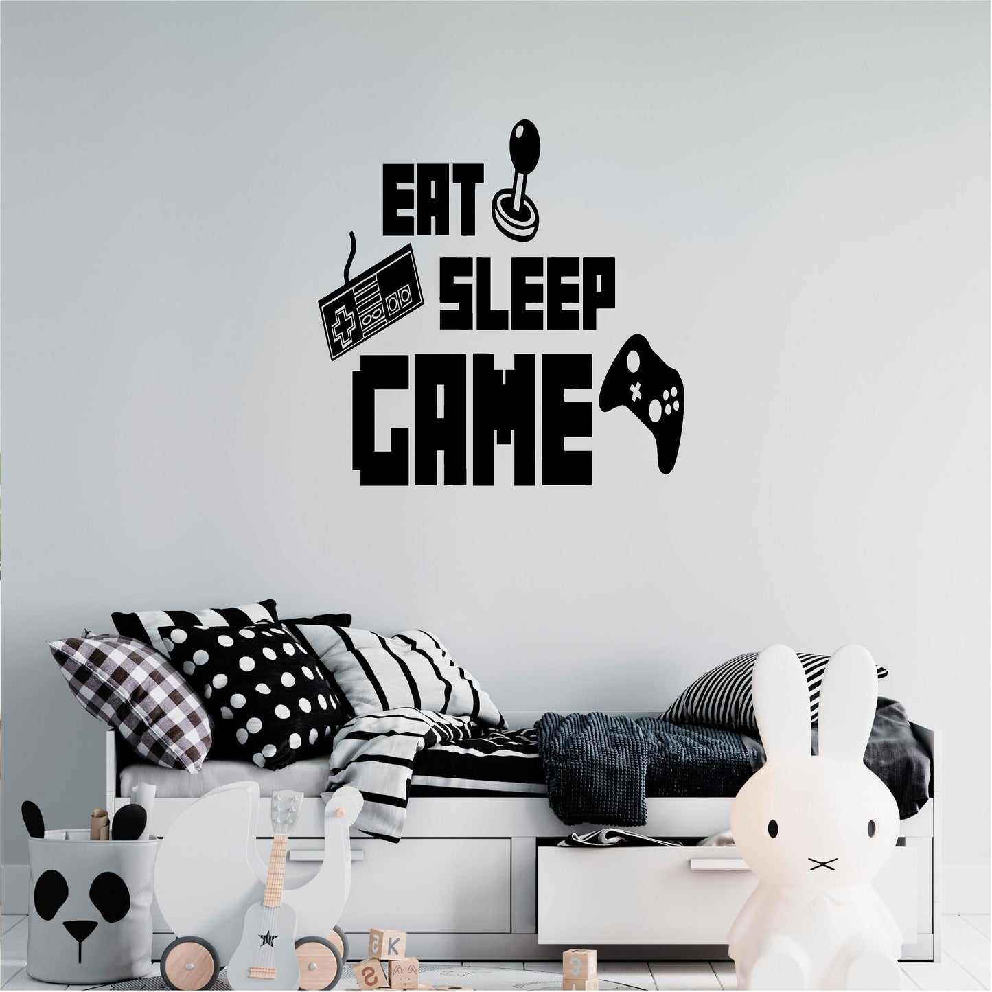 Black Eat Sleep Game wall decal above a monochrome bed