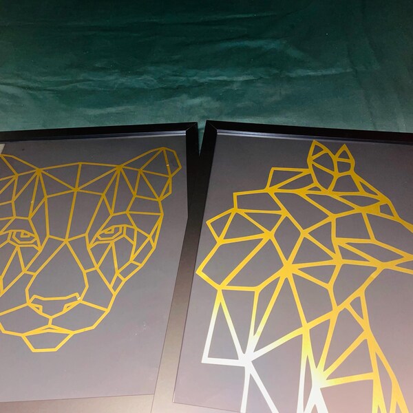 Gold geometric lioness and wolf designs displayed in two dark frames.