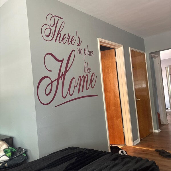 Large script home quote decal on a grey living room wall.