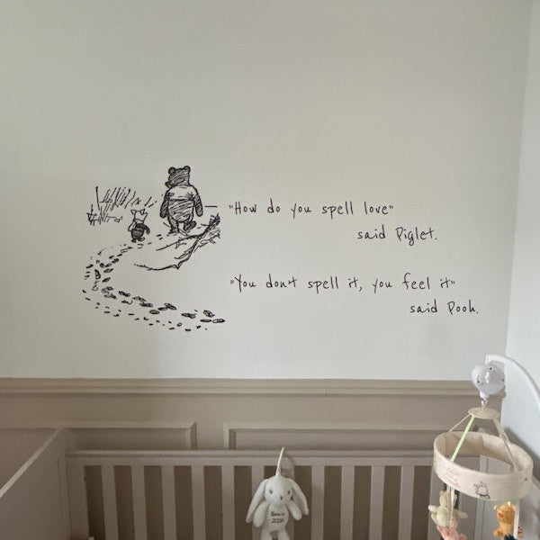 Black illustrated quote above a cot in a nursery.