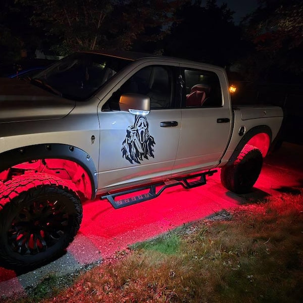 Black face design on a silver pickup truck door photographed at night.