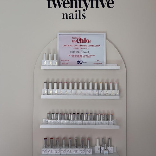 Black twentyfive nails lettering above a nail polish display.