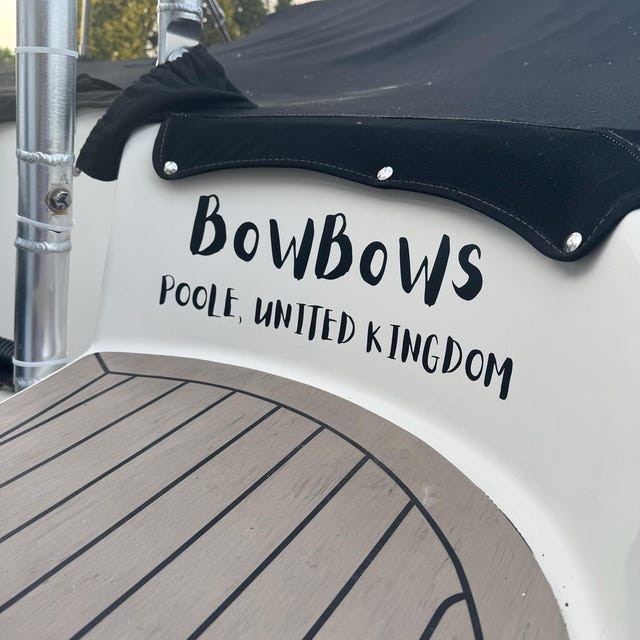 Black BowBows name and home port lettering on the stern of a boat.