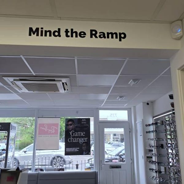 Black Mind the Ramp lettering above an interior shop opening.