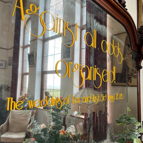 Gold wedding lettering applied to a large framed mirror.