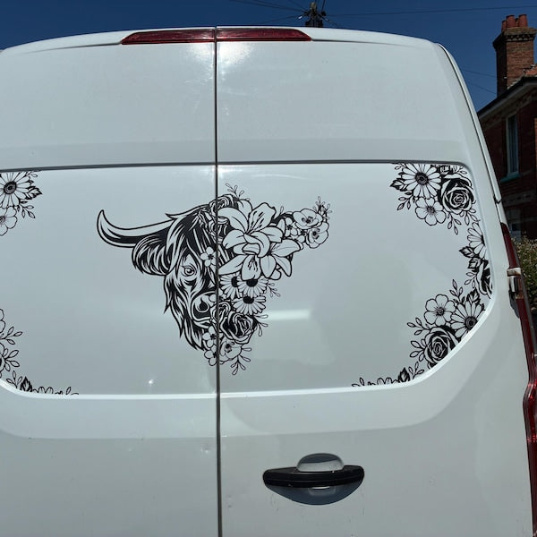 Black highland cow and floral decals across the rear doors of a white van.