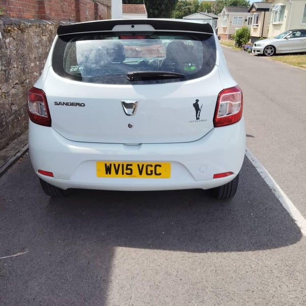 Small black remembrance silhouette on the rear of a white car.