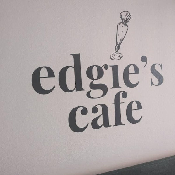 Black edgie's cafe lettering and illustration on a cafe wall.