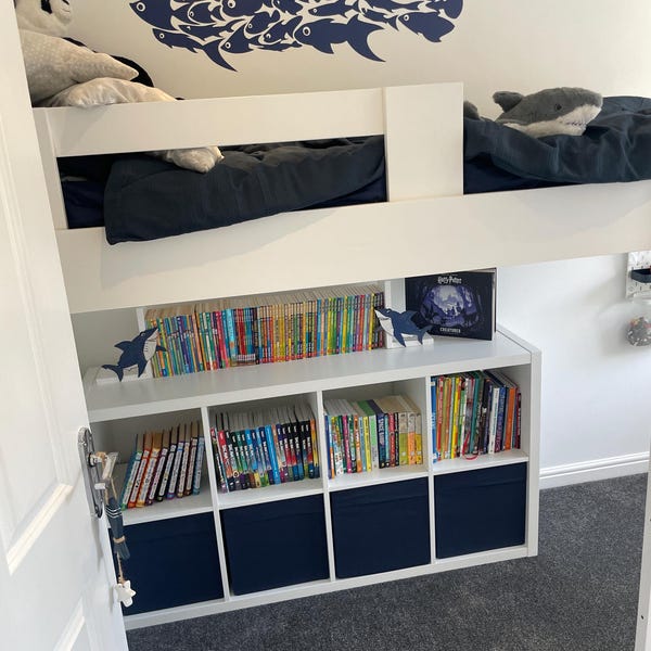 Dark shark-shaped fish design above a bunk bed in a child's bedroom.