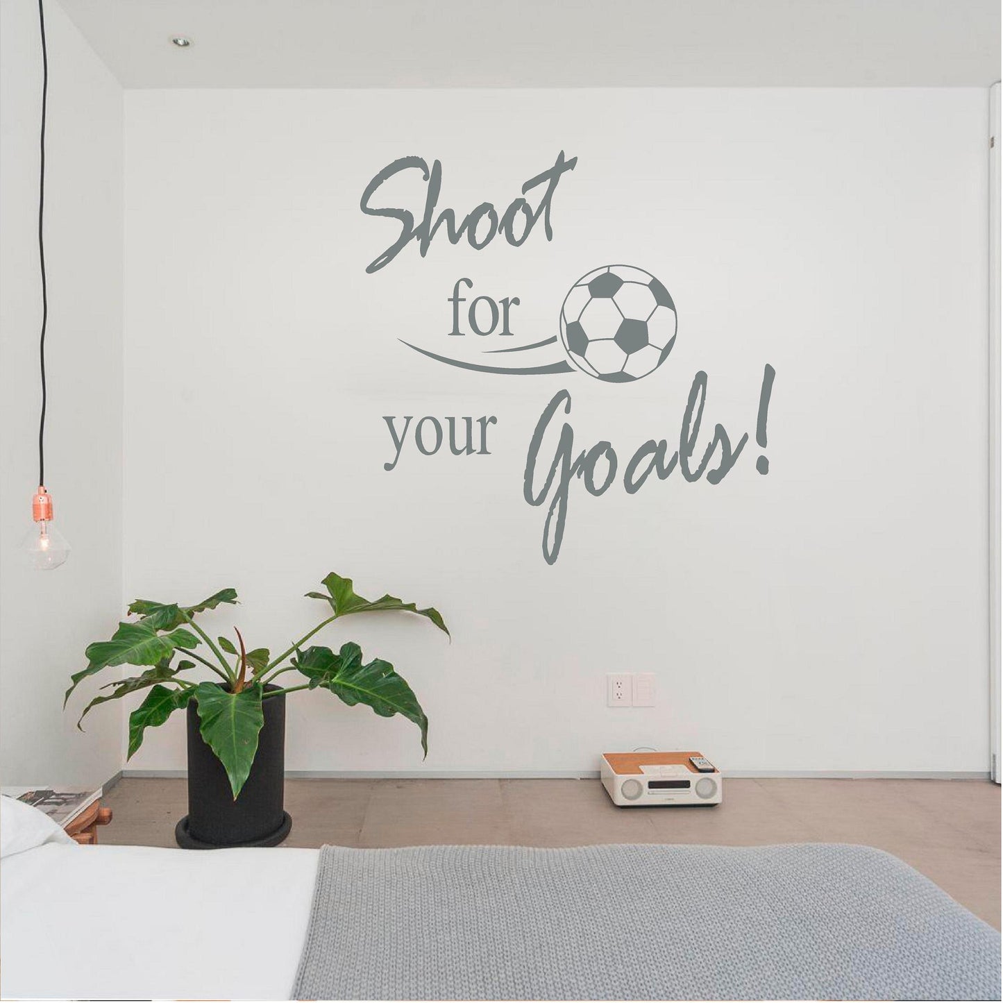 Grey Shoot for your Goals football wall decal beside a houseplant