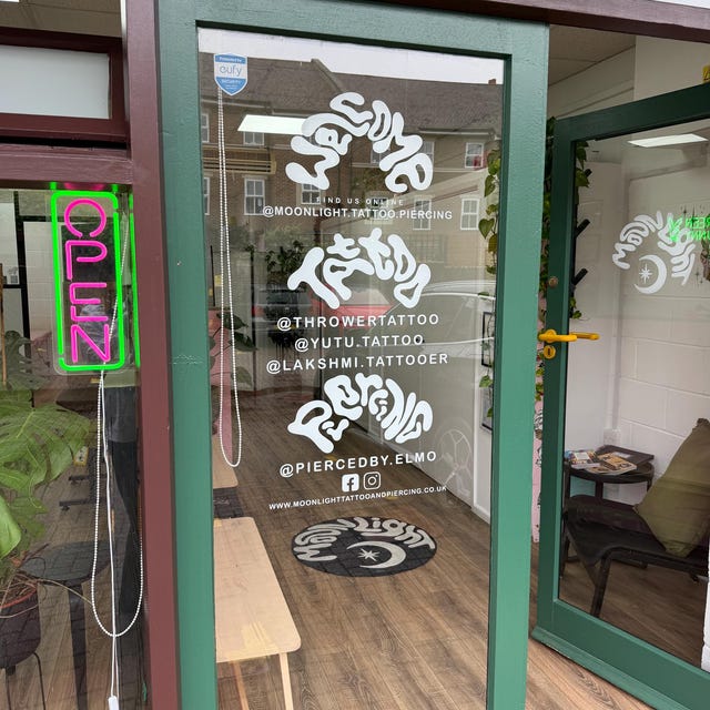 RT's Etsy review photograph of white business lettering and logos on a glass shop door