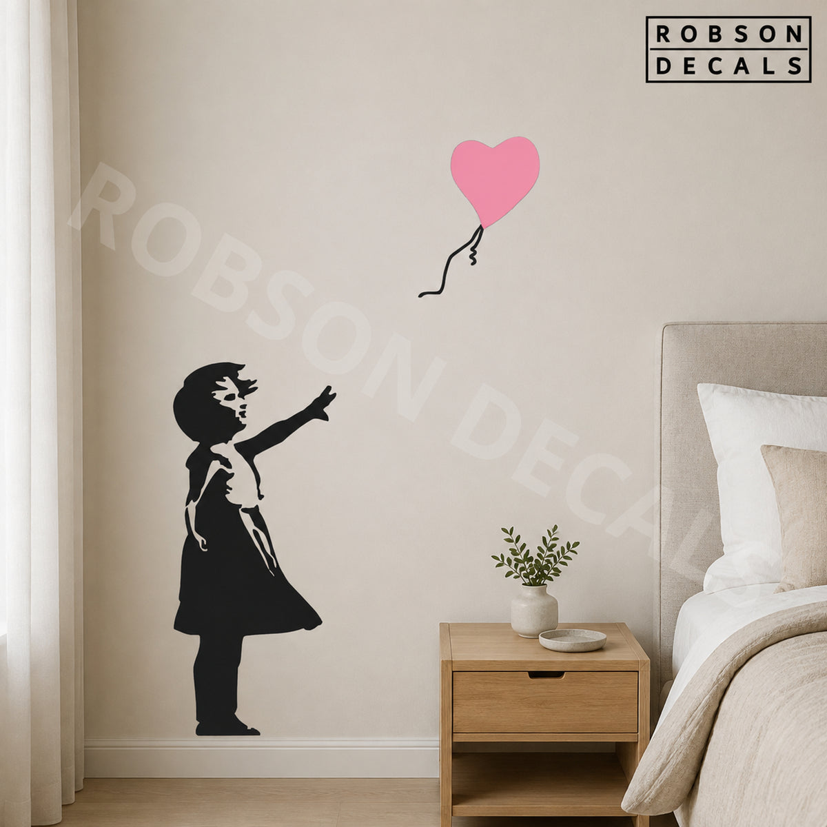 Black Balloon Girl wall decal with a light pink heart balloon beside a bed, shown as pictured. Robson Decals logo and watermark.