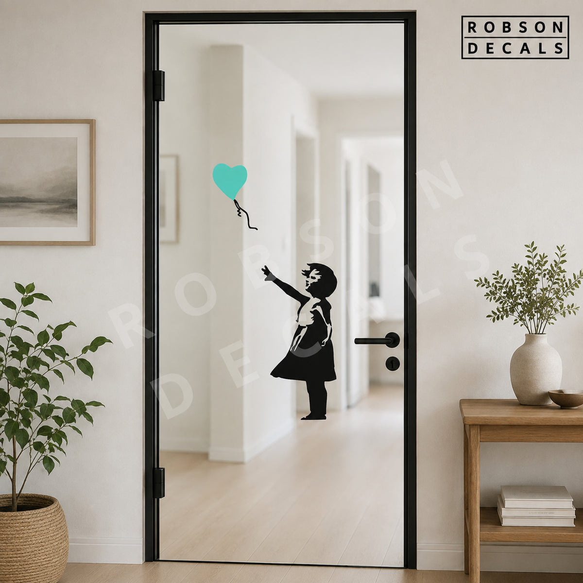Mirrored Balloon Girl decal on a glass door: girl on the right reaches left towards a mint heart balloon. Robson Decals watermark.