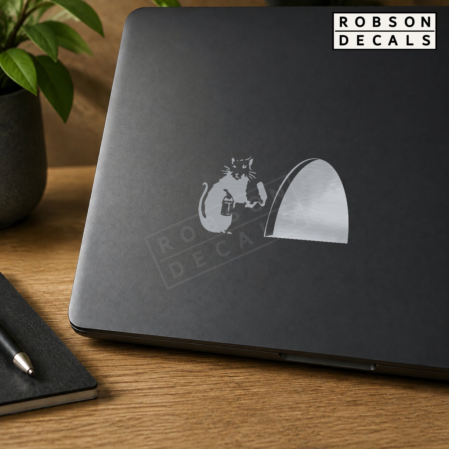 Silver Little Mouse and Mouse Hole vinyl decal on a dark laptop lid. Robson Decals branded mock-up.