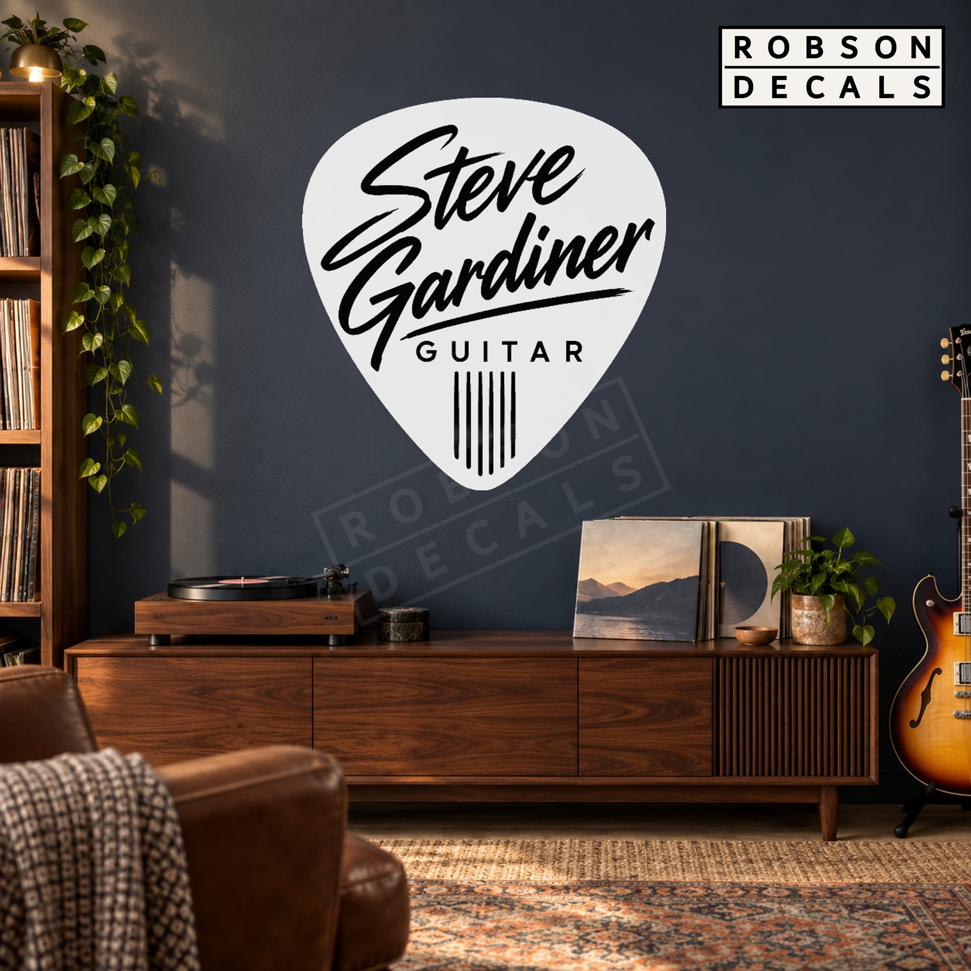 White guitar pick decal with black personalised lettering on a dark music room wall