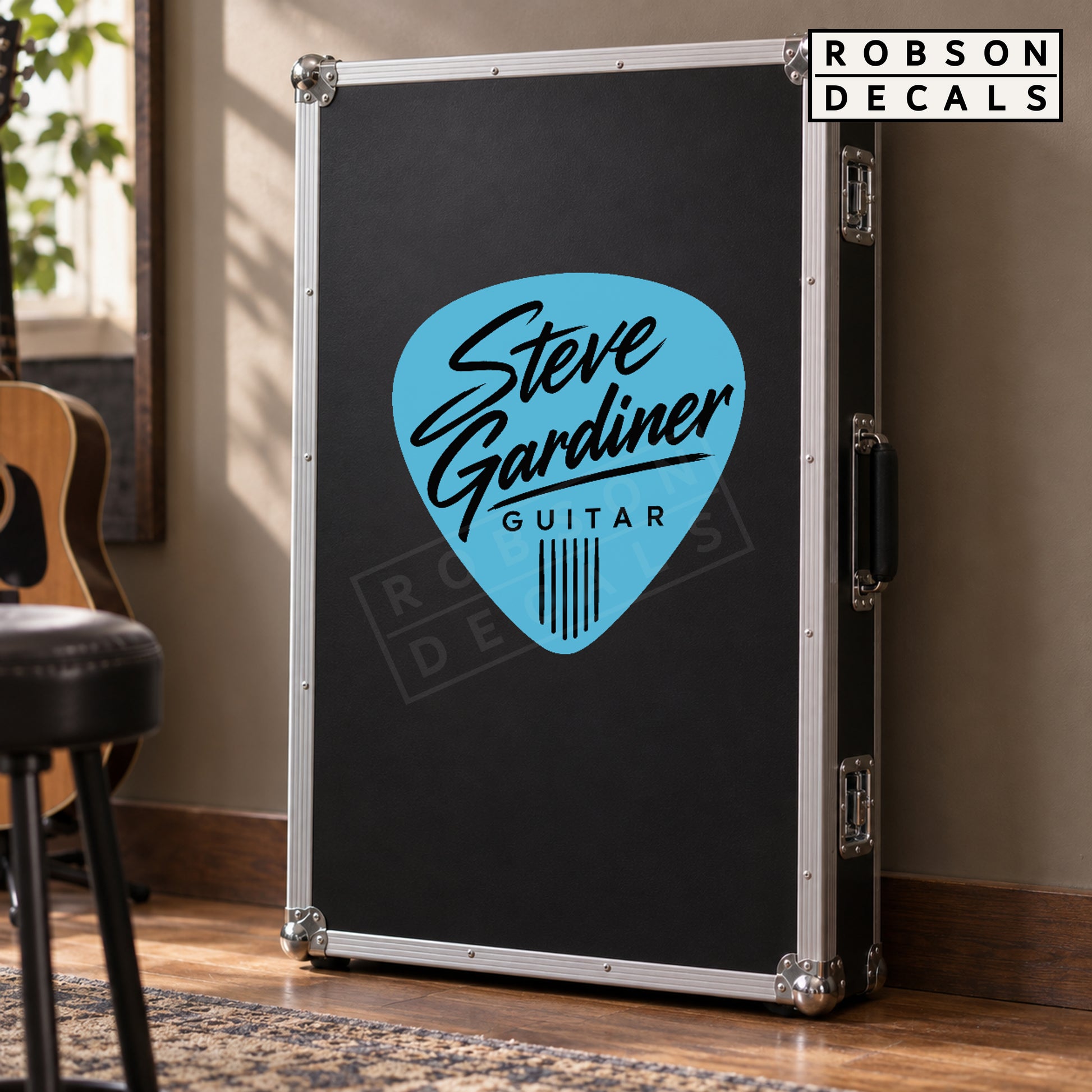 Pastel blue guitar pick decal with black lettering on a smooth guitar flight case
