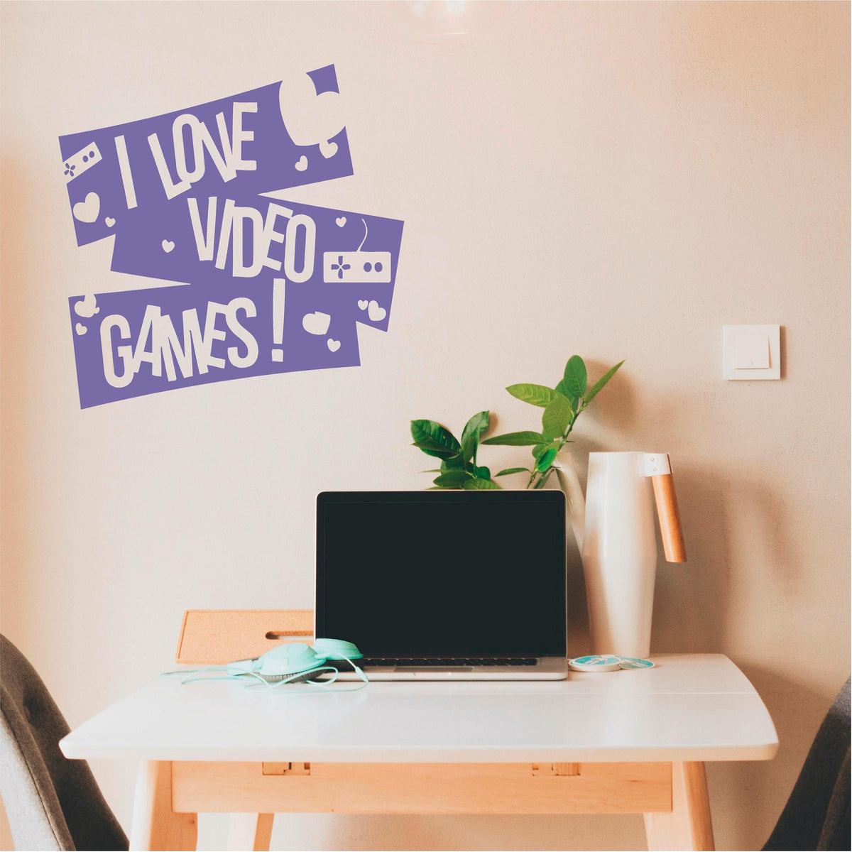 Purple I Love Video Games wall decal with controllers and hearts above a desk with a laptop.