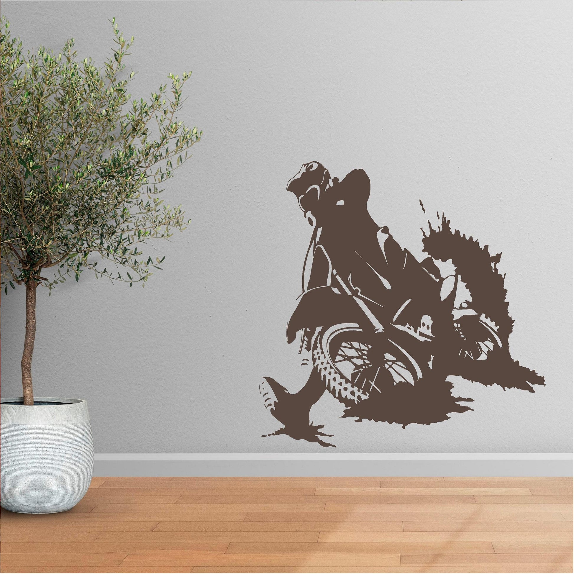 Brown motocross rally rider wall decal beside a potted tree