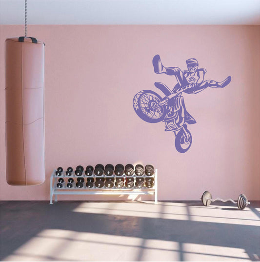 Purple freestyle motocross stunt wall decal above weights in a gym