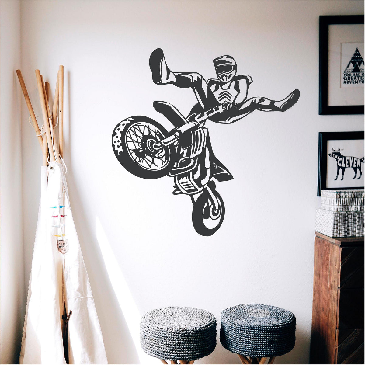 Black freestyle motocross rider wall decal above two knitted stools