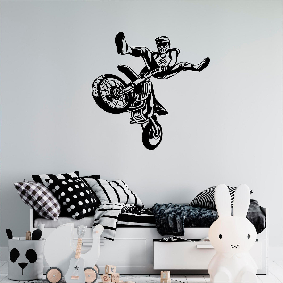 Black freestyle motocross rider wall decal above a child's daybed
