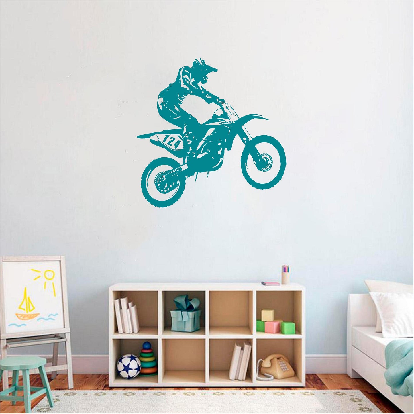 Teal motocross rider wall decal above a cube shelf in a child's room
