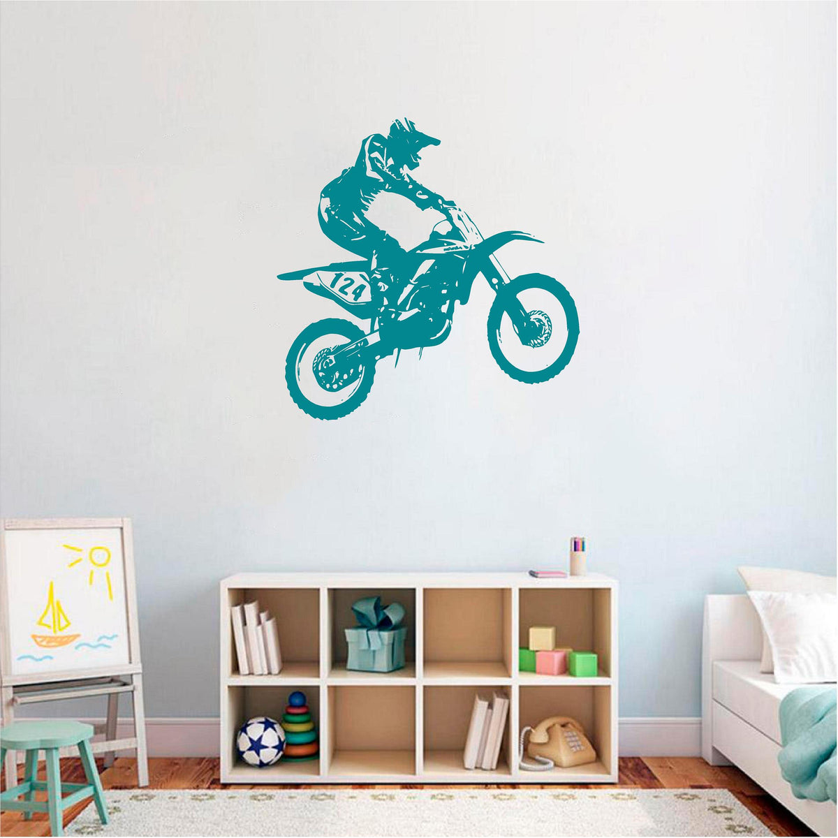 Teal motocross rider wall decal above a cube shelf in a child's room