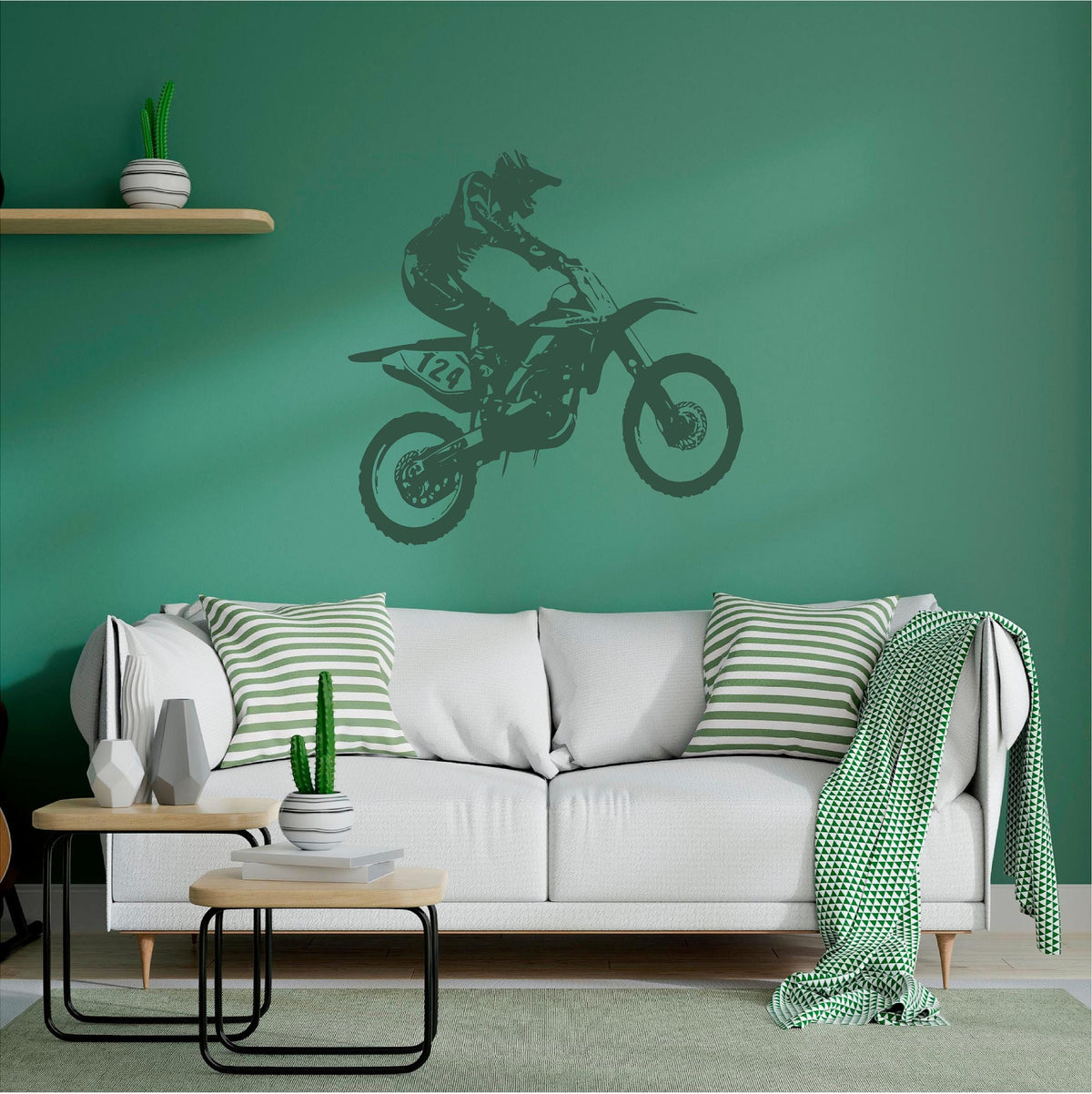 Dark green motocross rider wall decal above a white sofa on a green wall
