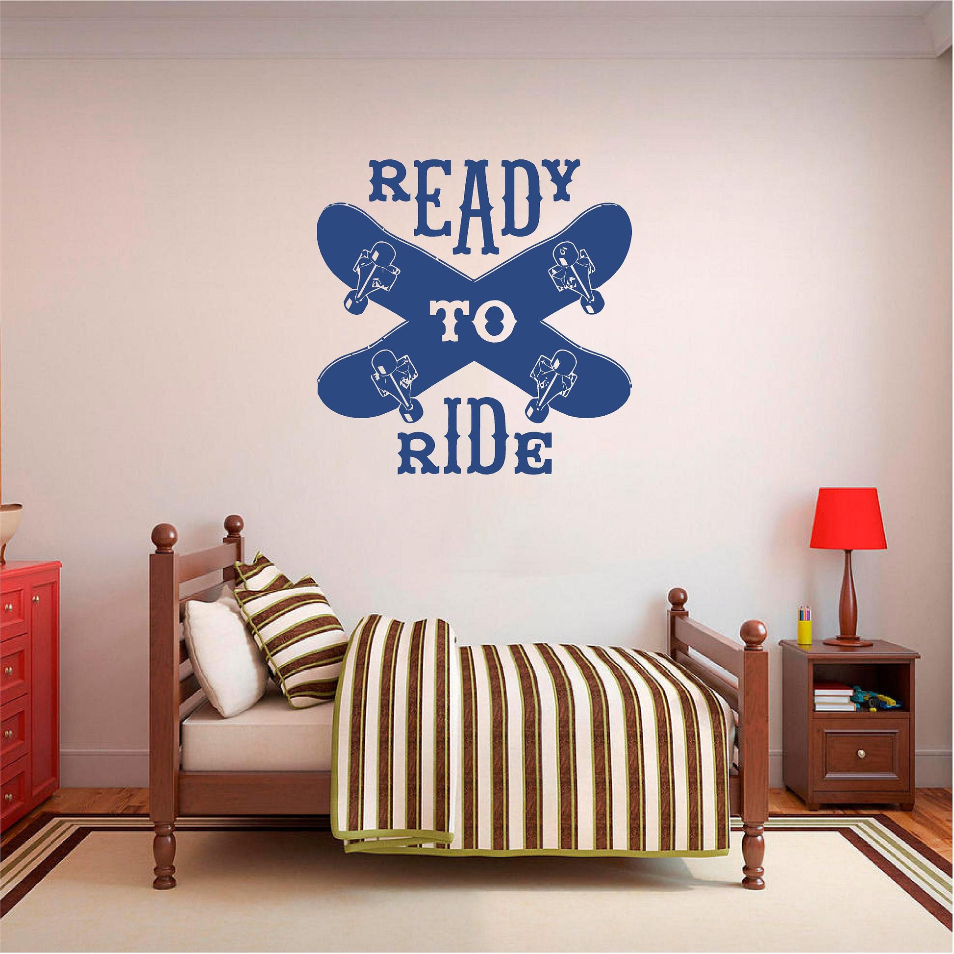 Navy blue Ready to Ride wall decal with two crossed skateboards above a wooden single bed.