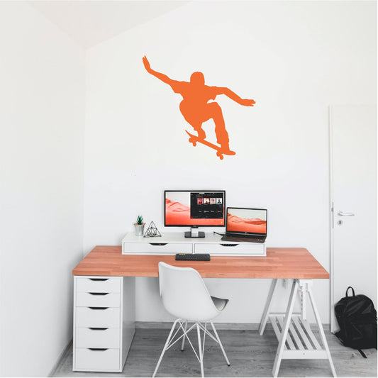 Orange ollie skateboarder wall decal above a computer desk