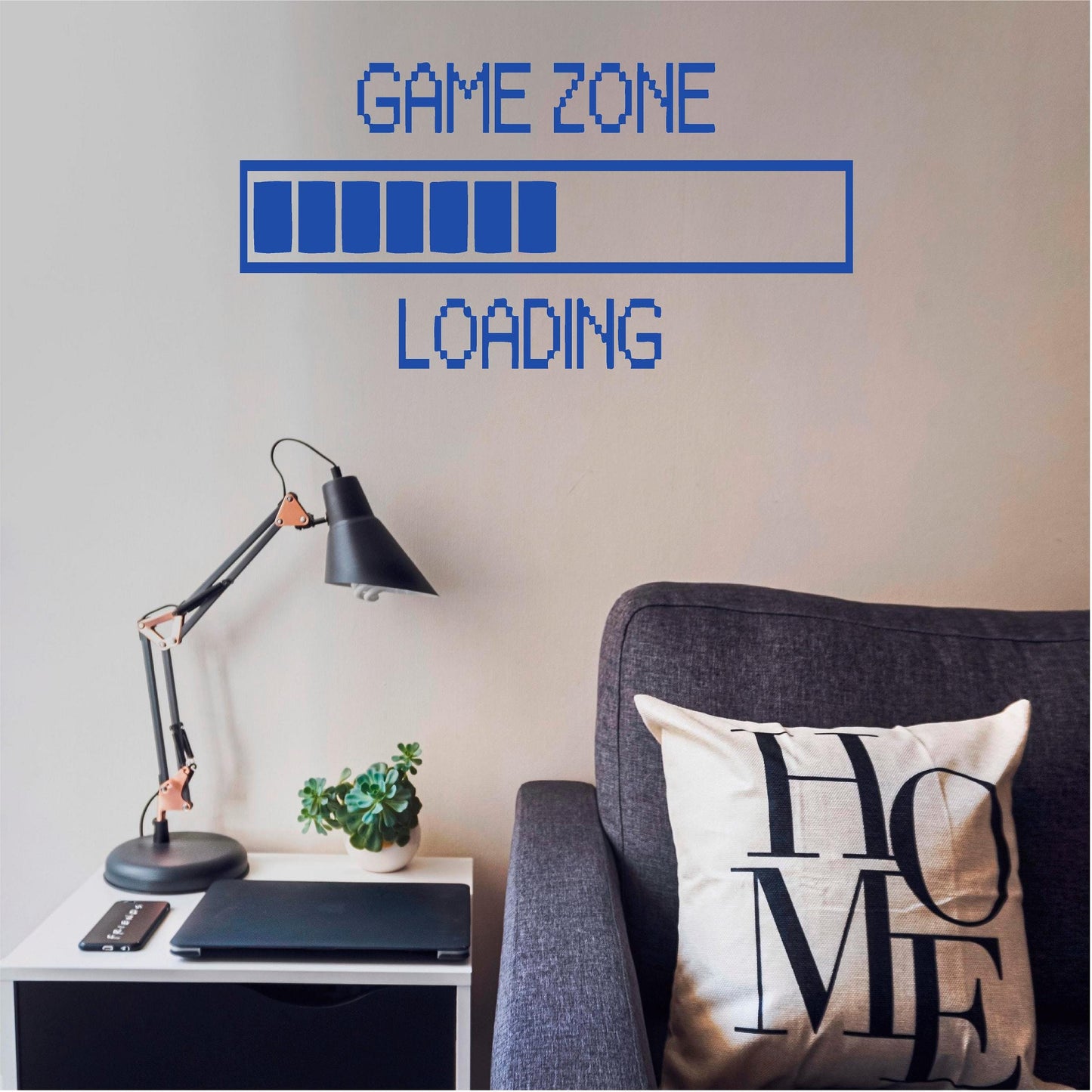 Blue Game Zone Loading wall decal above a grey armchair