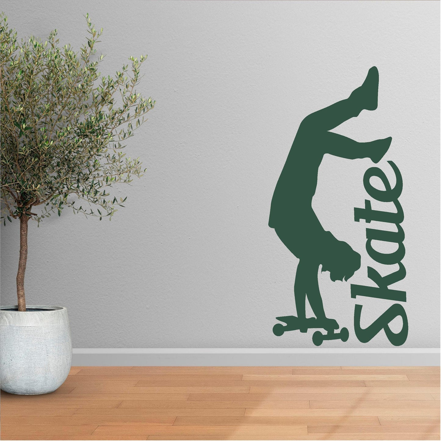 Dark green handstand skater wall decal beside a potted tree