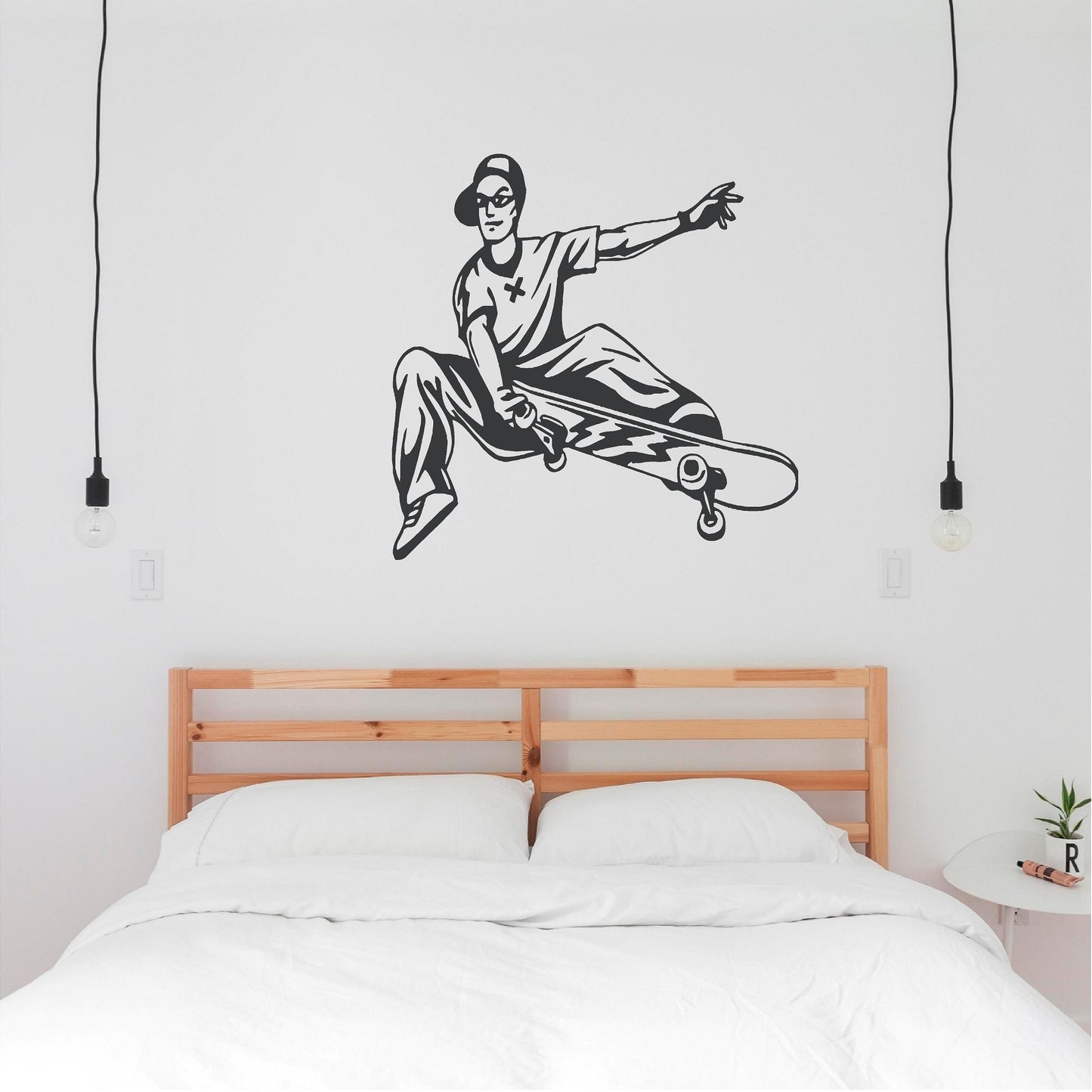 Dark grey skateboarder trick wall decal above a double bed