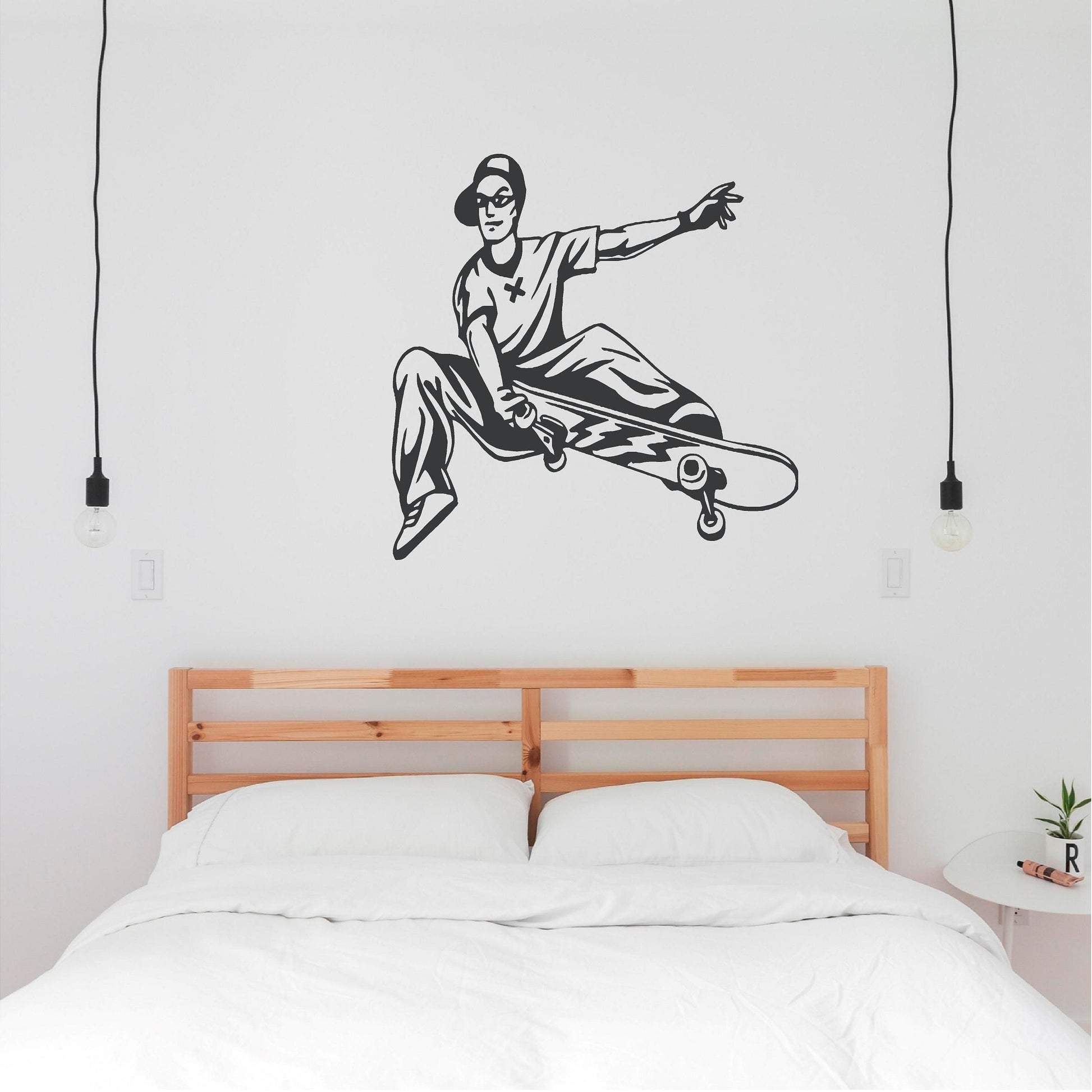 Dark grey skateboarder trick wall decal above a double bed
