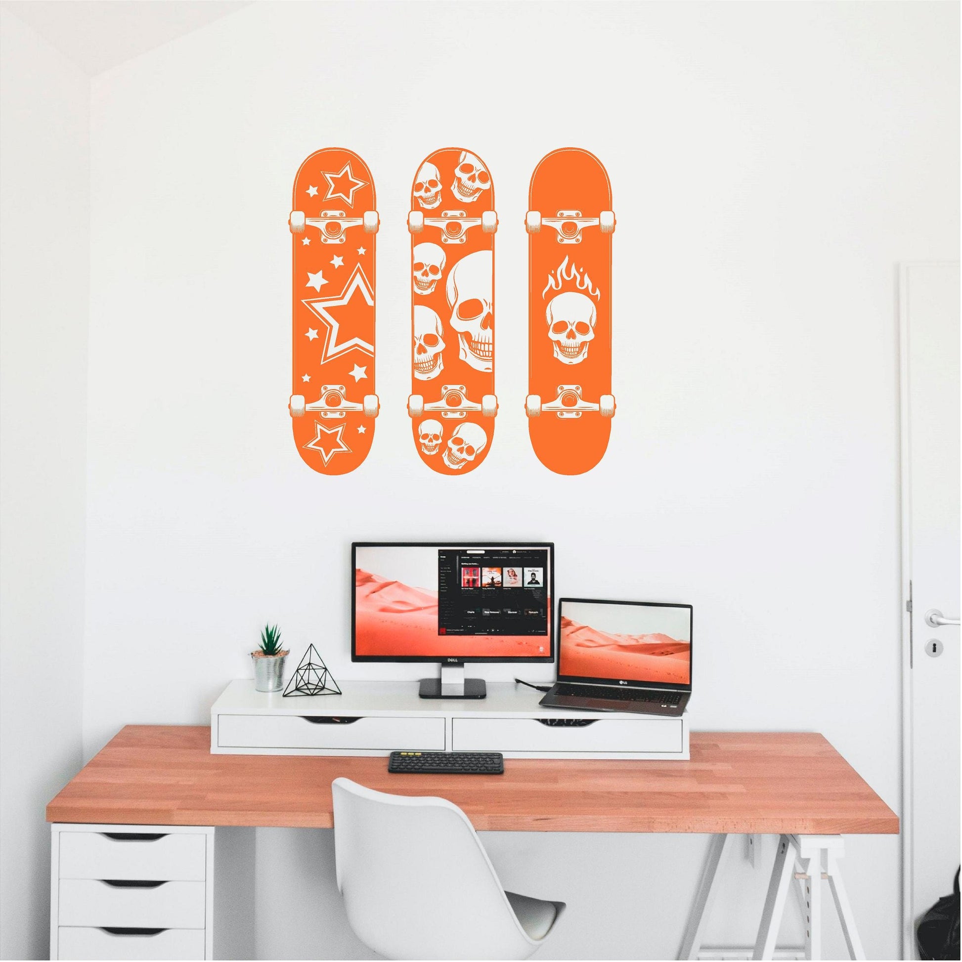 Orange set of three skull and star skateboard wall decals above a computer desk