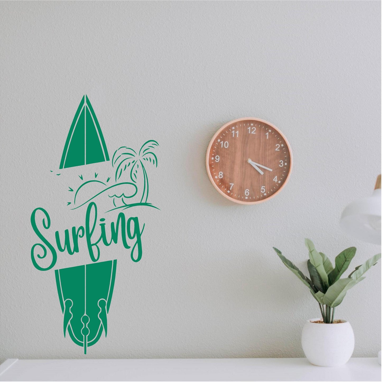 Green Surfing wall decal beside a clock and plant