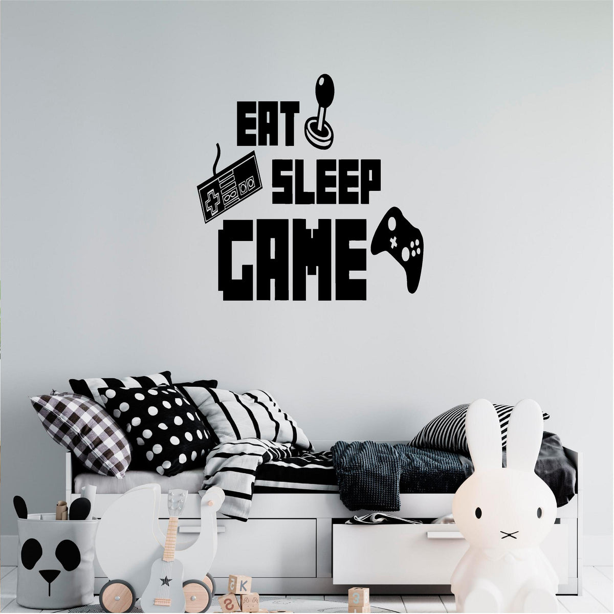 Black Eat Sleep Game wall decal above a monochrome bed