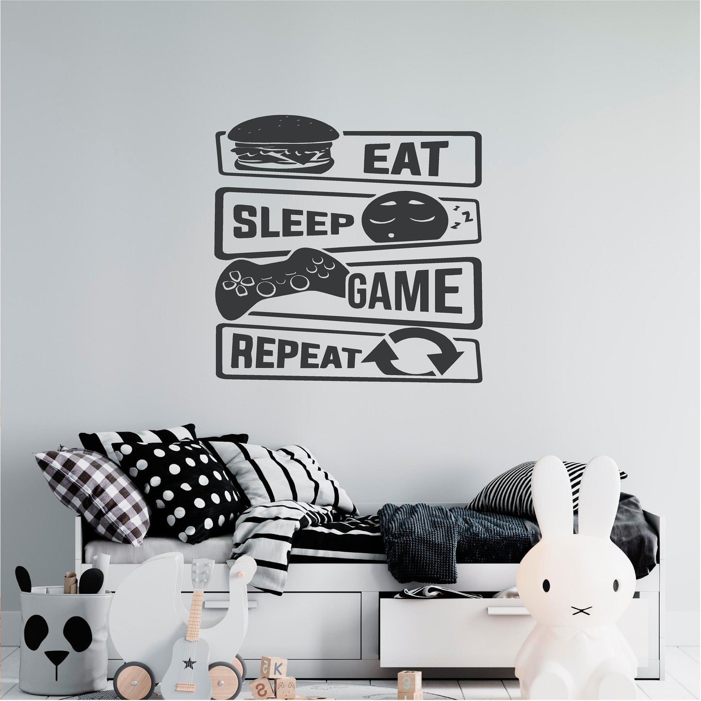 Black Eat Sleep Game Repeat wall decal above a monochrome bed
