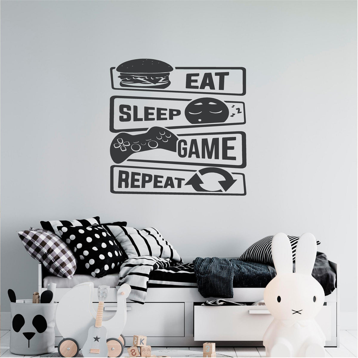 Black Eat Sleep Game Repeat wall decal above a monochrome bed