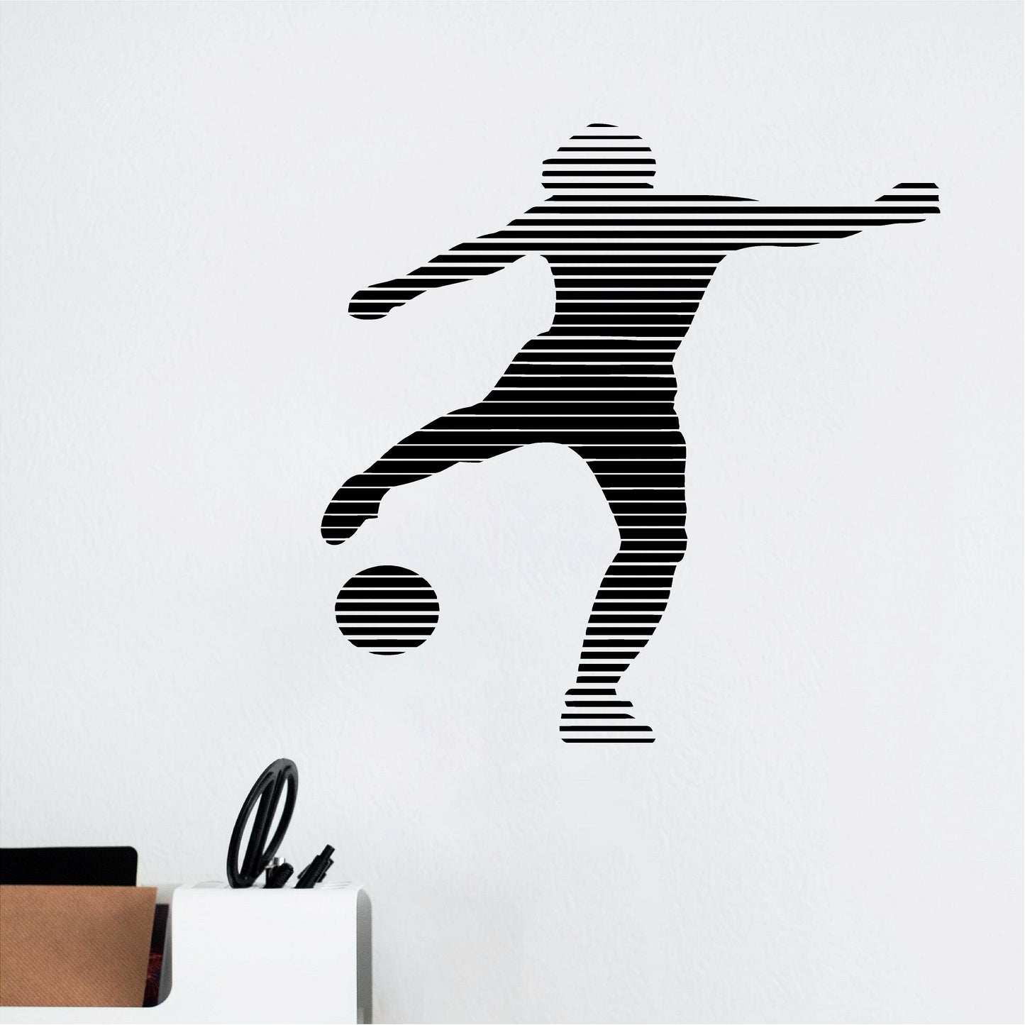 Black striped footballer wall decal beside a pen holder