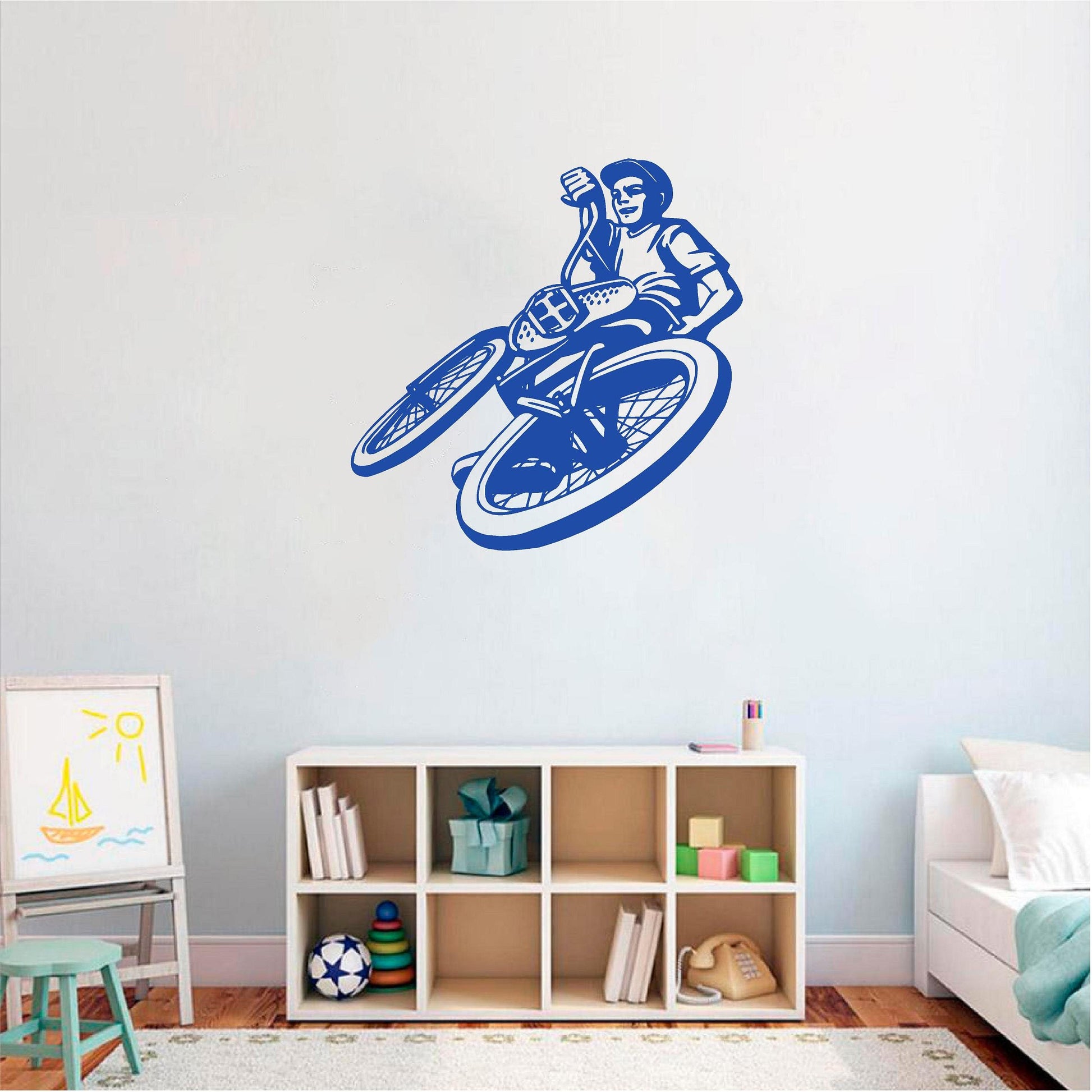 Blue BMX rider wall decal above bedroom shelving
