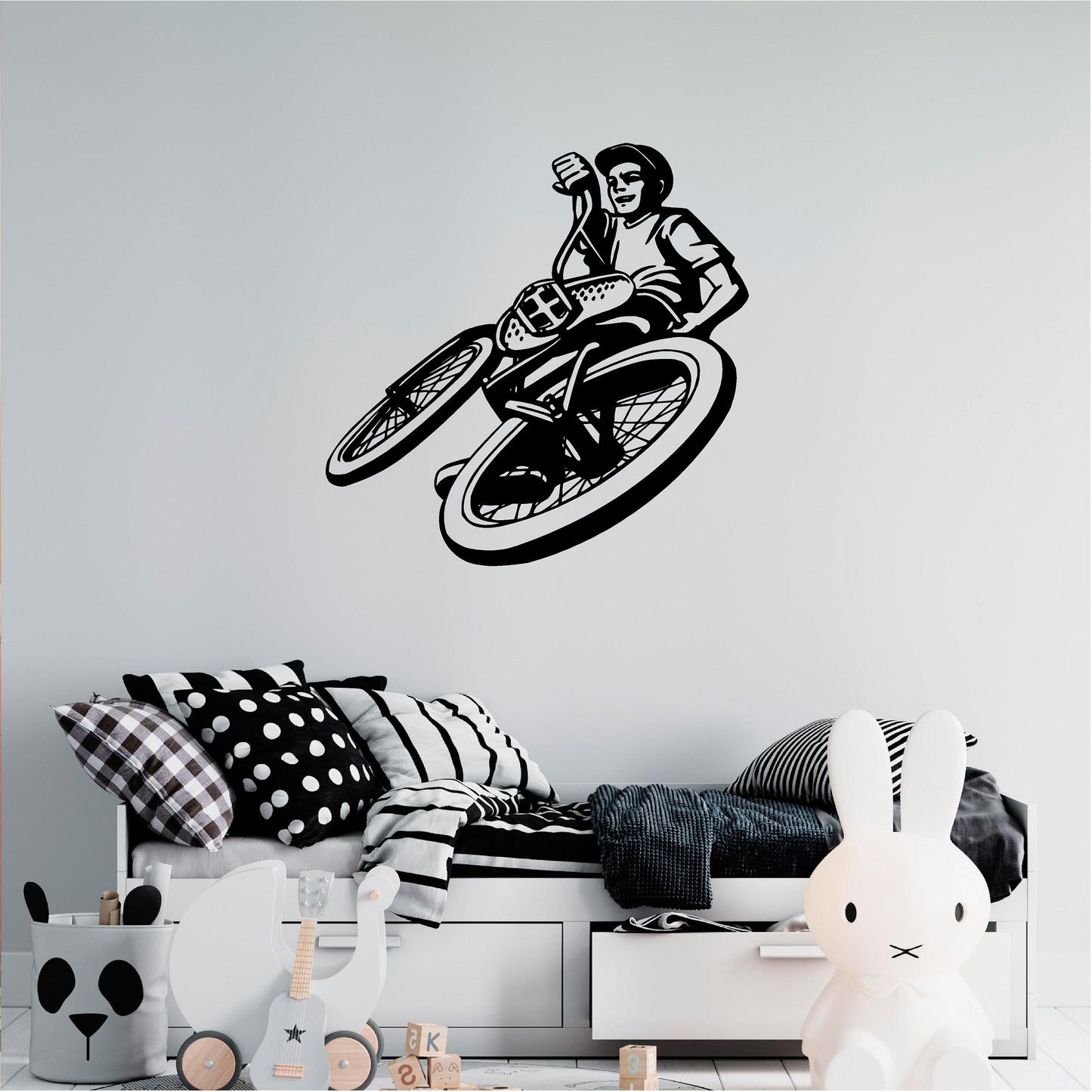 Black BMX rider wall decal above a monochrome bed