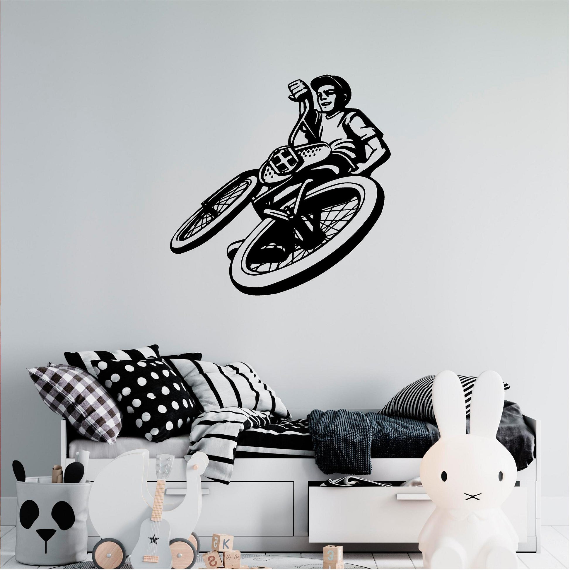 Black BMX rider wall decal above a monochrome bed