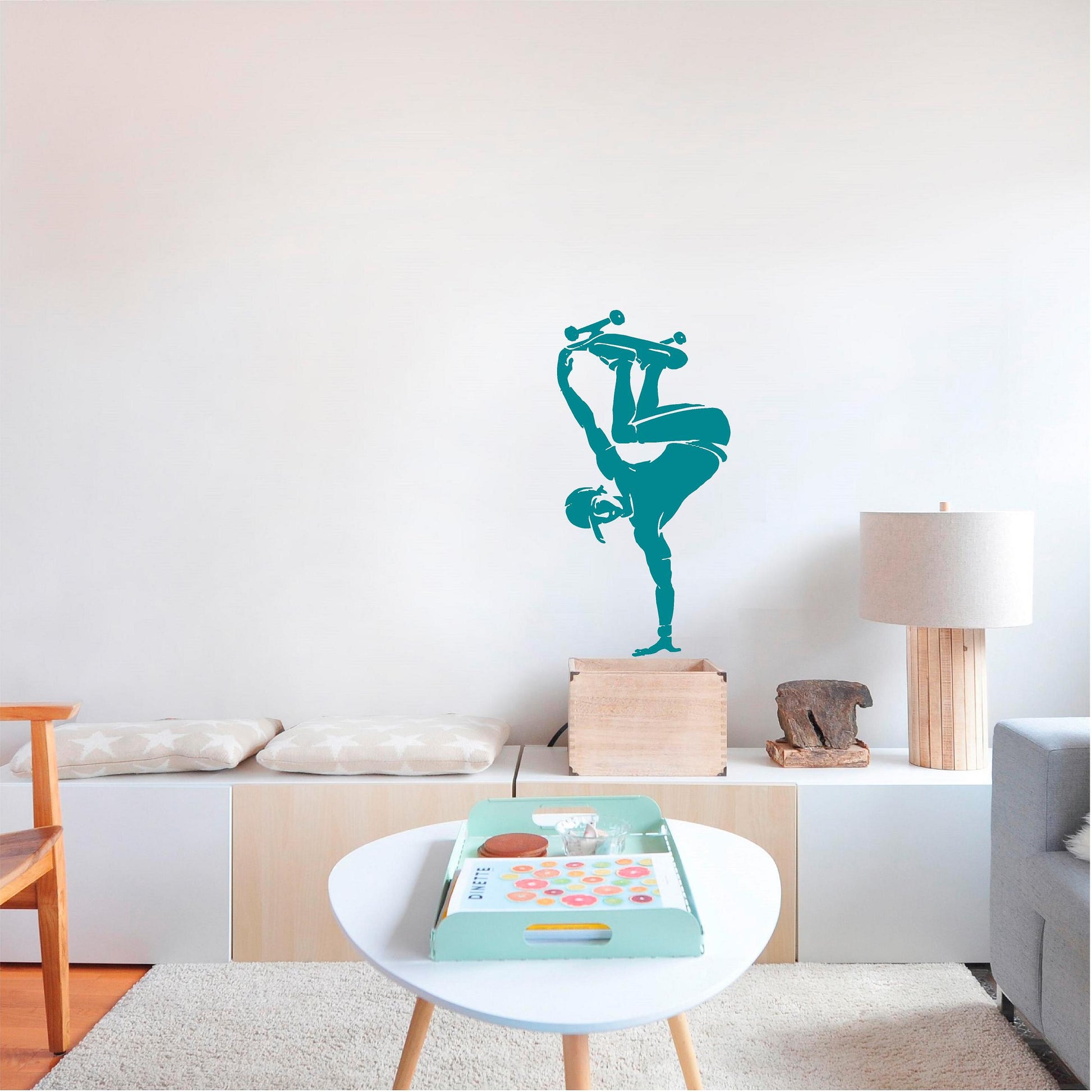 Turquoise skateboarder handplant wall decal above low shelving