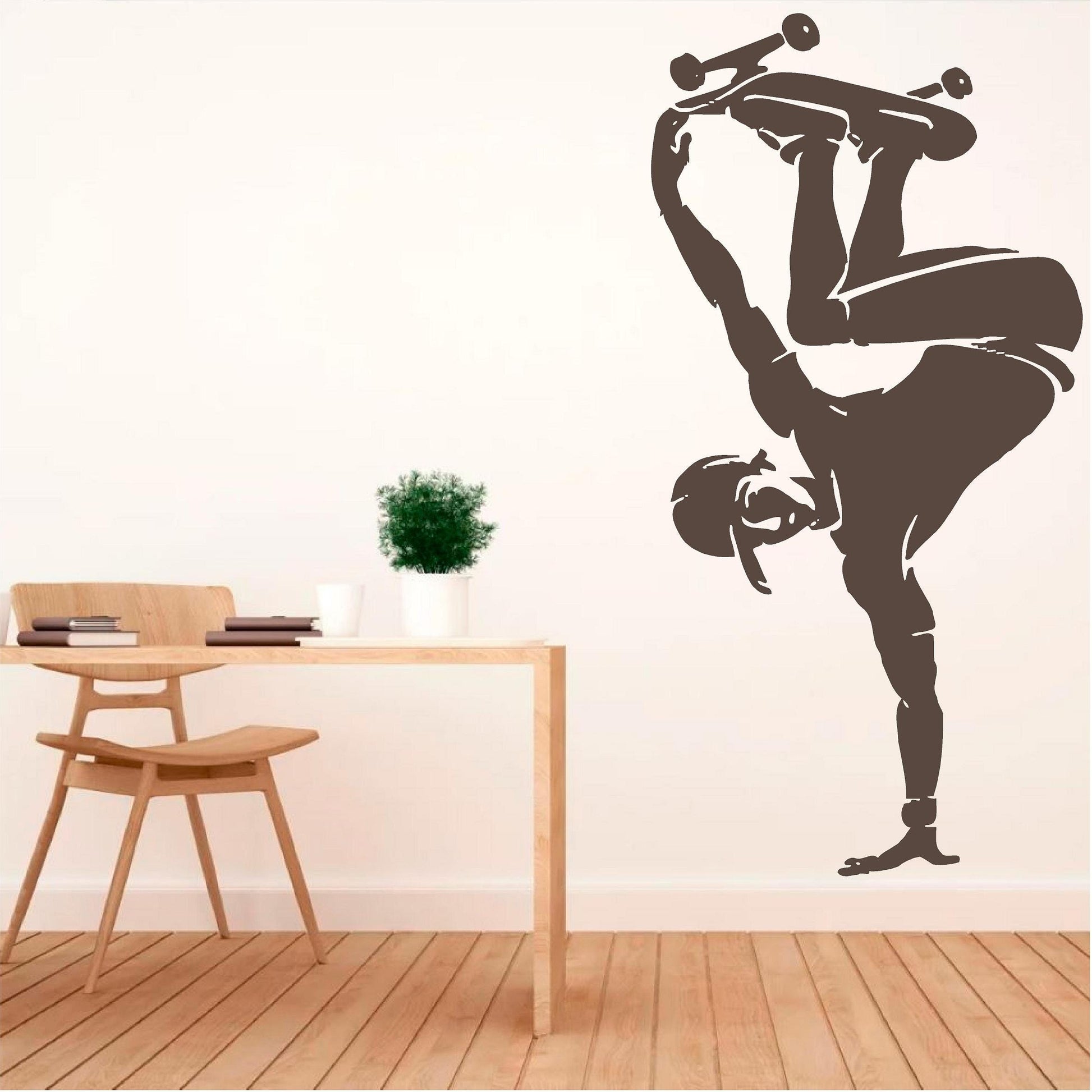 Brown skateboarder handplant wall decal beside a wooden desk