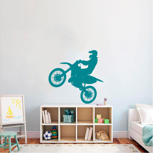 Turquoise motocross rider wall decal above bedroom shelving