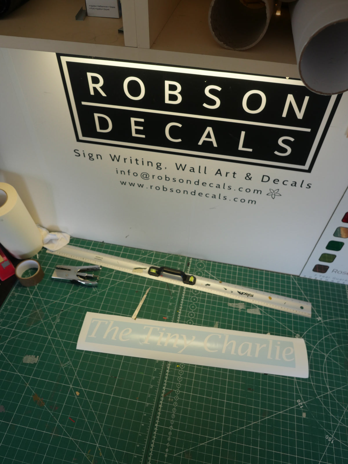 The Tiny Charlie lettering — prepared vinyl lettering or artwork, workshop photograph