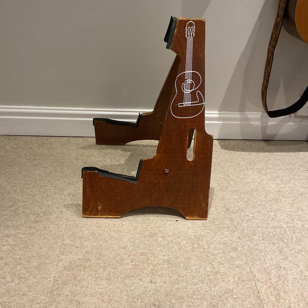 White guitar illustration decal applied to a wooden guitar stand.